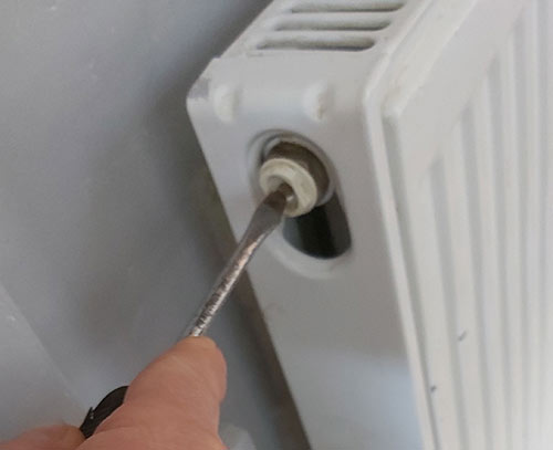 Undoing the bleed screw on a radiator