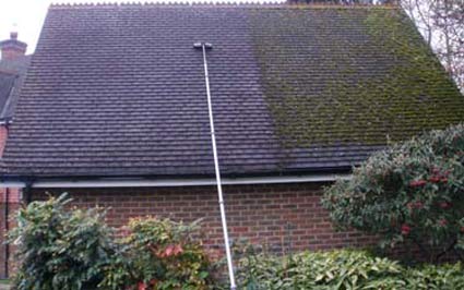 Brushing moss from a roof