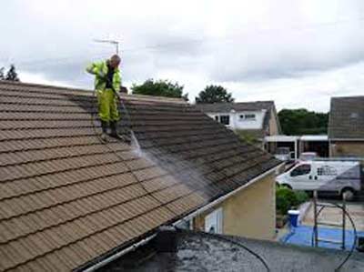 Removing moss from a roof with a pressure washer