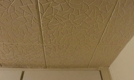 Polystyrene tiles covering bedroom ceiling