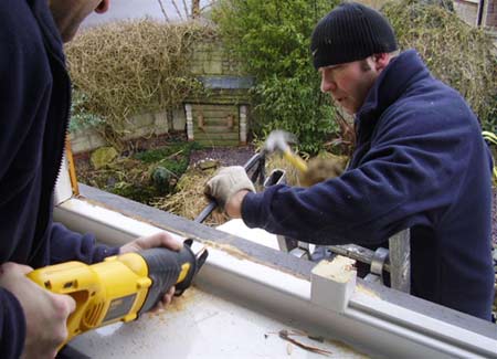 Removing the window sill by creating an angled cut and levering up with a wrecking bar