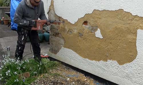 Removing old render using a breaker and cranked chisel