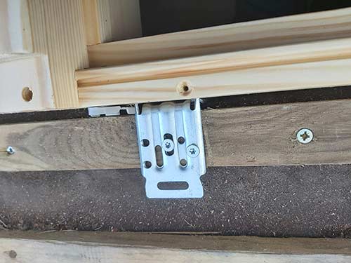 Screw window brackets up firmly and secure window in place in hole