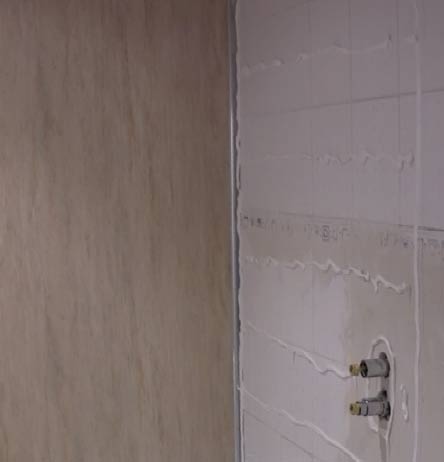 Shower panel adhesive on tiled bathroom wall