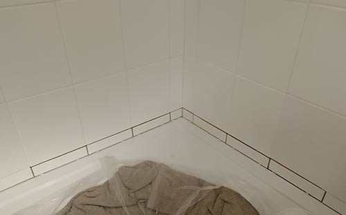 Tiles fixed in place above shower tray