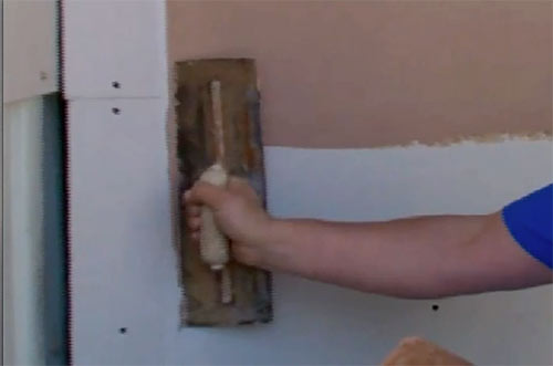 Applying plaster to wall using a plasterers trowel