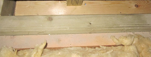 Sliding door rail brace screwed between joists to help support the rail