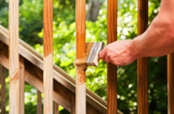 Applying decking stain with a brush to balustrades and stairs