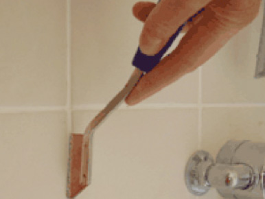 Removing tile grout with a grout rake