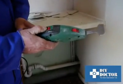 Using a tile scraper to remove ceramic tiles
