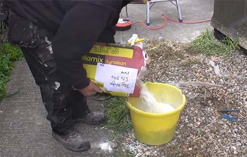 Adding Tyrolean powder to bucket for mixing