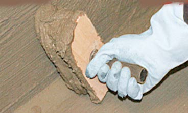Applying a tanking slurry to a basement wall