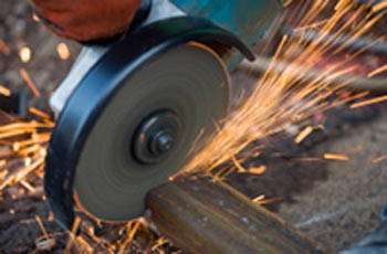 Cutting through a steel bar with an angle grinder