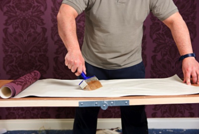 Applying paste to wallpaper on a pasting table