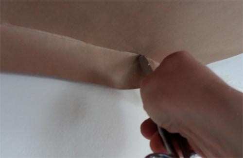 Scoring line between ceiling and wall with scissors